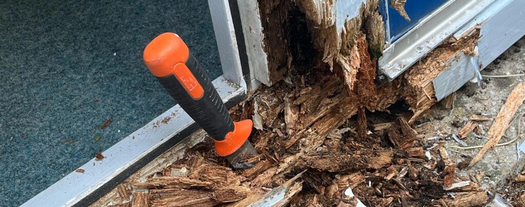 Aangetast houten kozijn met zichtbare houtrot schade